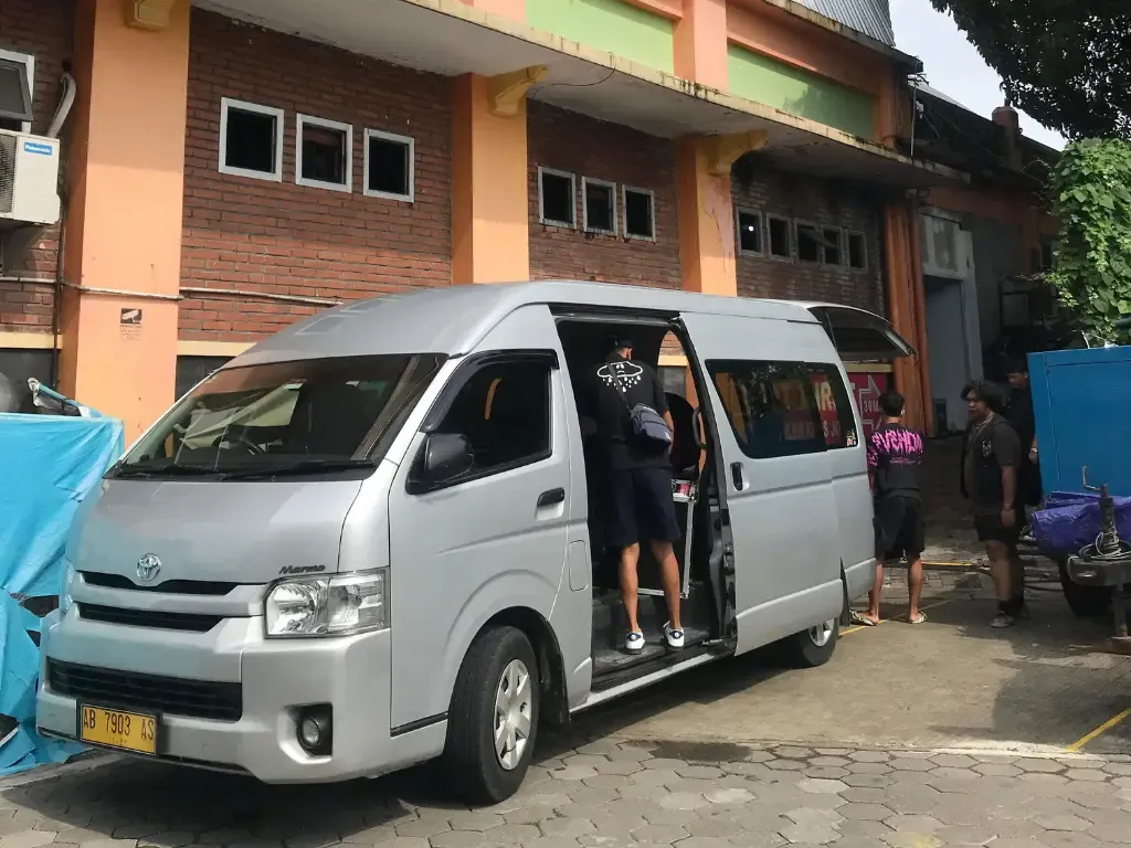 Toyota HiAce Commuter Nusa Indah Transport di depan gedung
