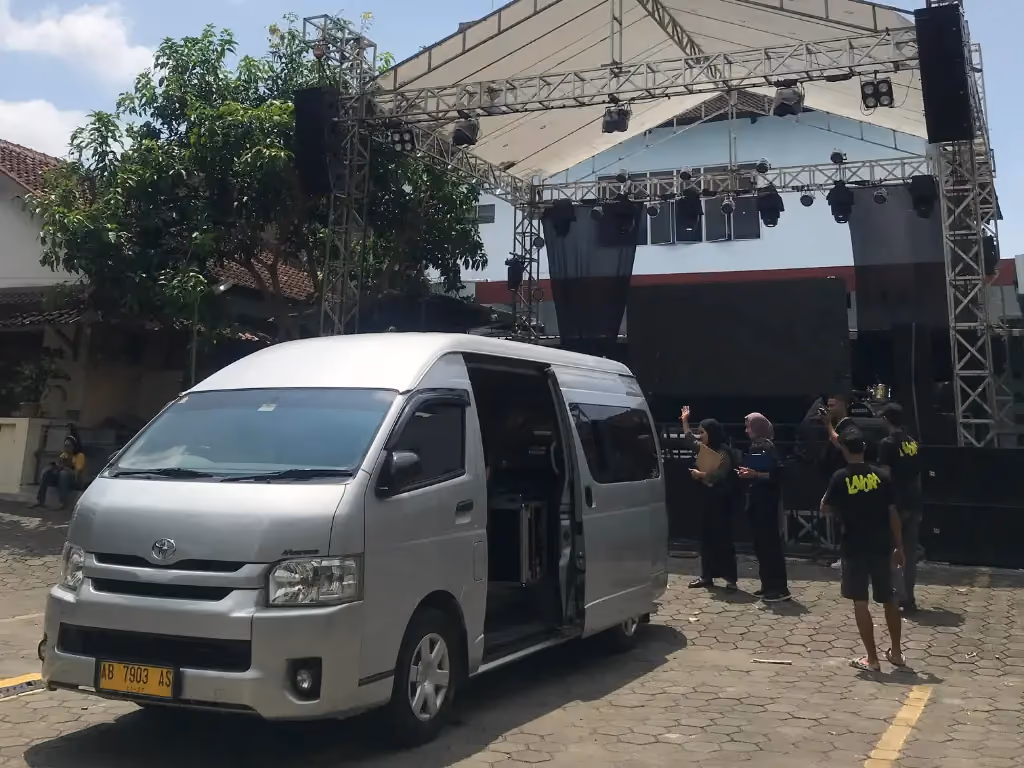 Unit HiAce terparkir di area kegiatan acara